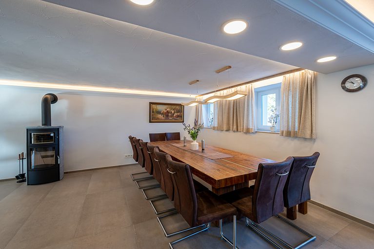 ein Esszimmer mit einem Holztisch, der von Stühlen umgeben ist