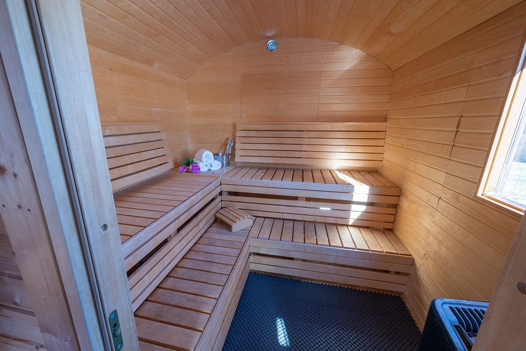 ein hölzerner Saunaraum mit einer Glastür.