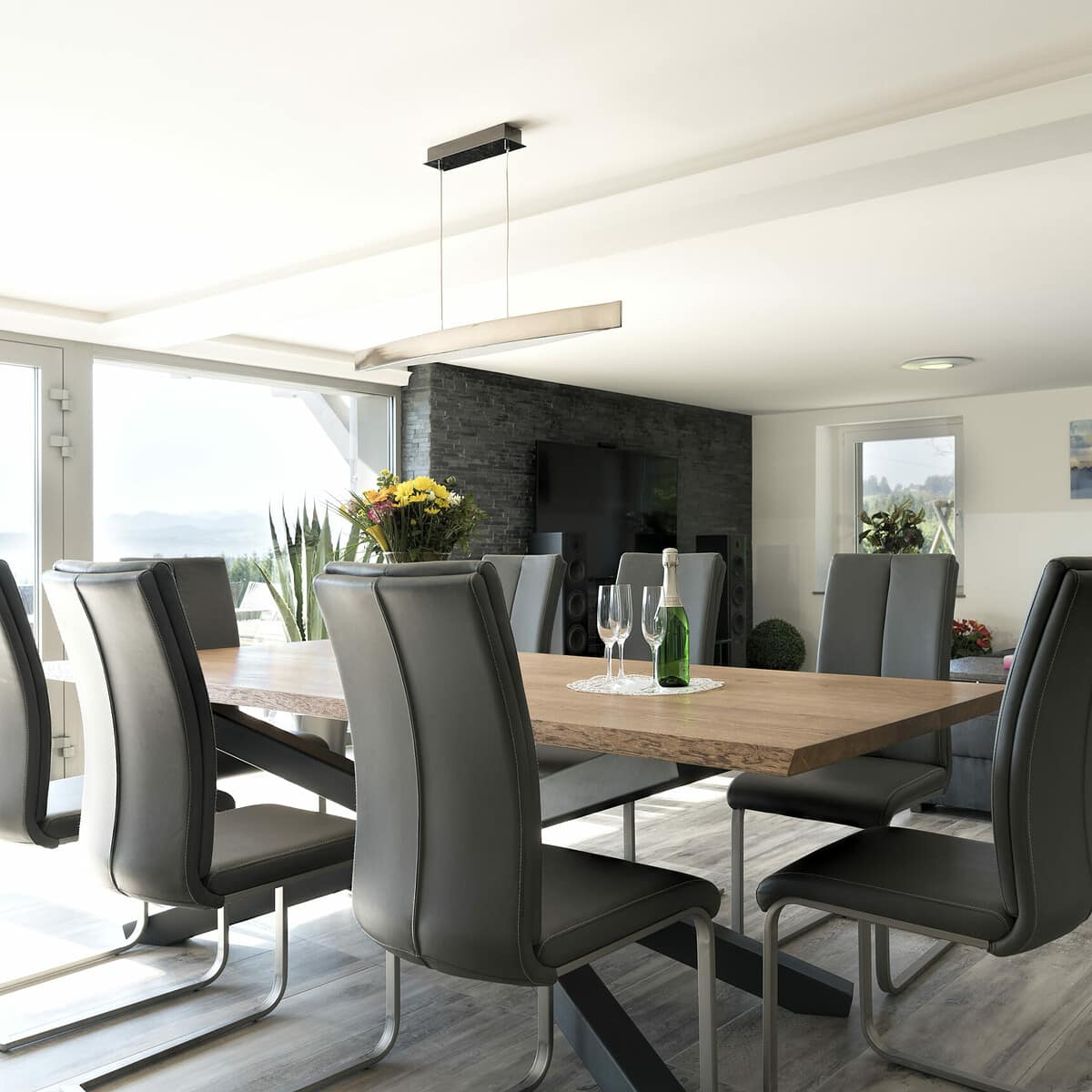 ein Esstisch mit Stühlen und einer Blumenvase.